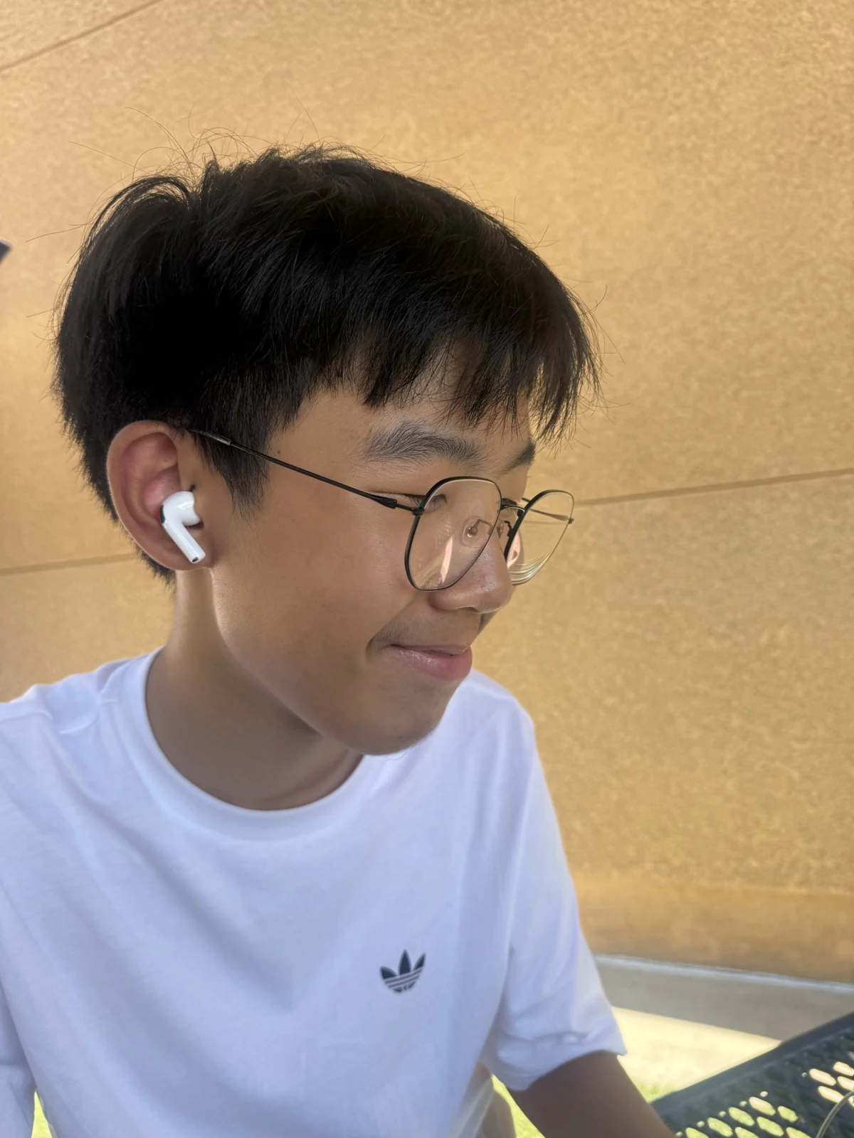 An outdoor portrait with glasses and earbuds