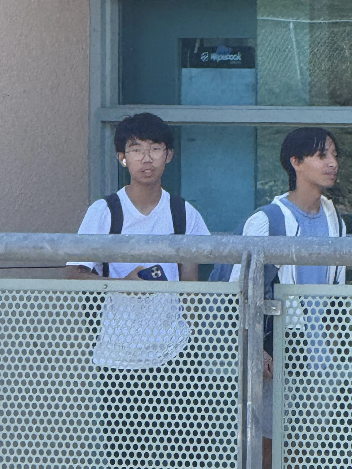 Standing beside a friend behind a railing