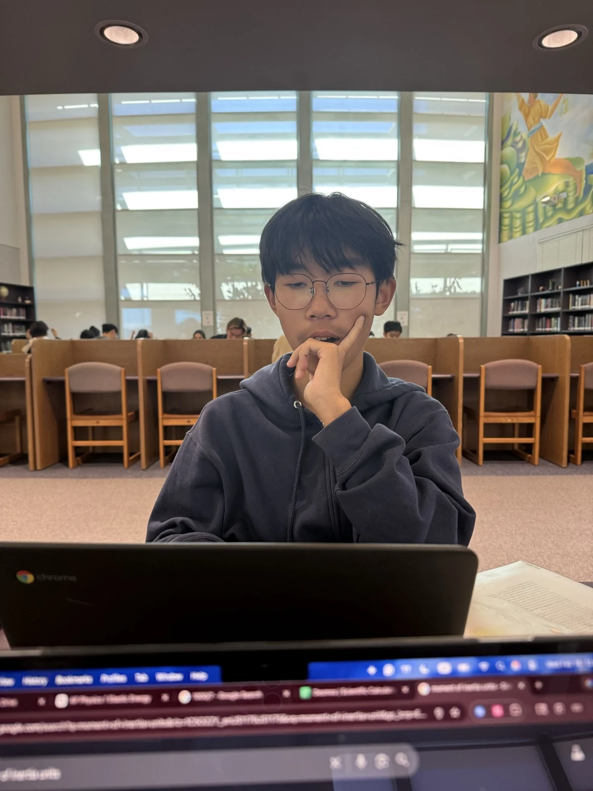Sitting at a library table with a laptop